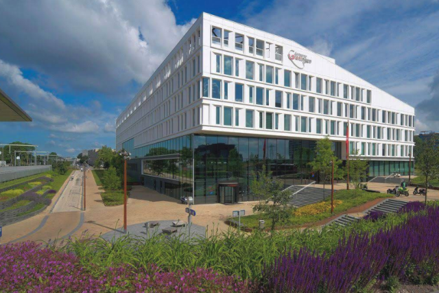 Groot hoekig wit gebouw aan Harm Buiterplein 1 Groningen met logo van gemeente Groningen op de gevel.